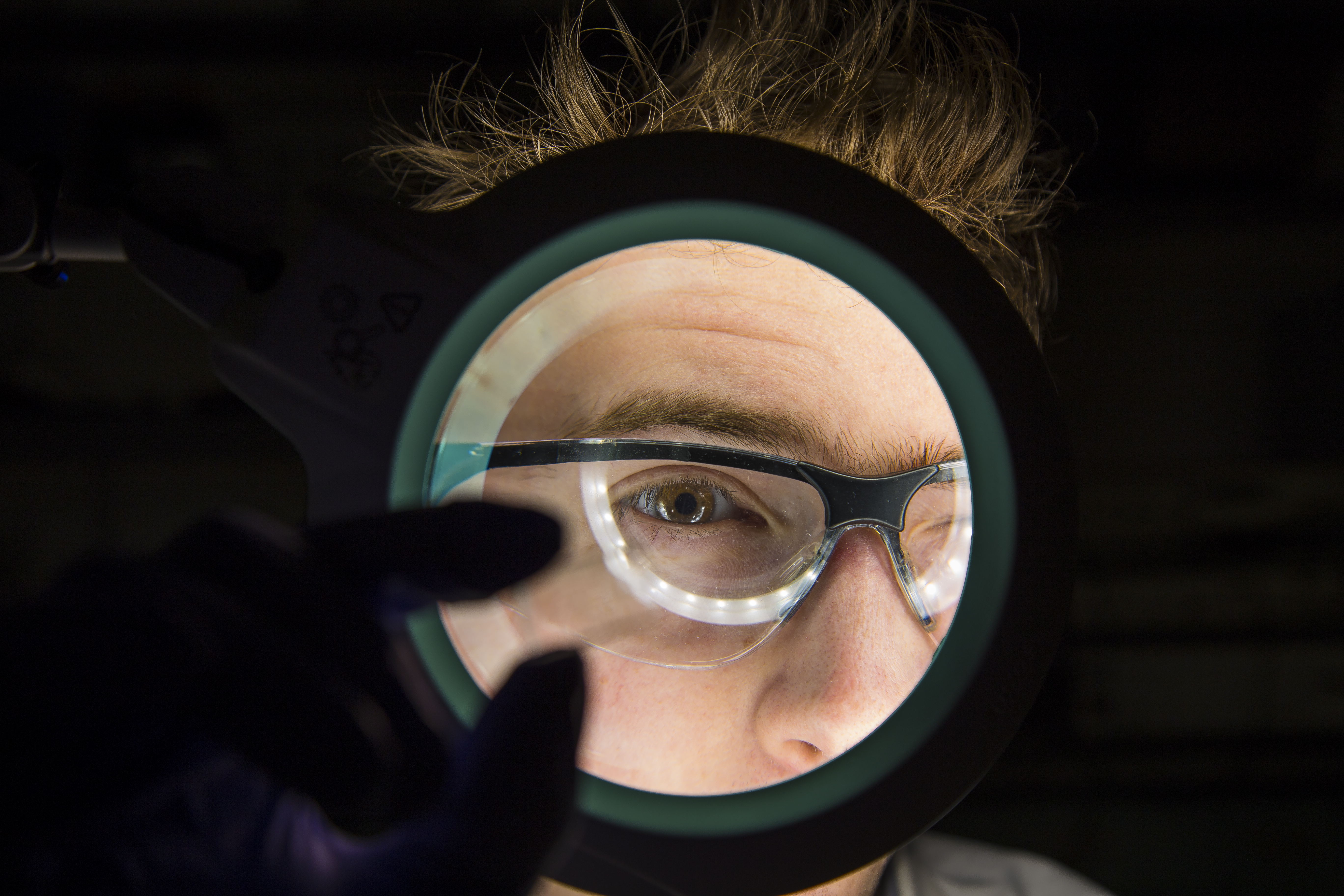 A scientist viewing a microfluidic chip