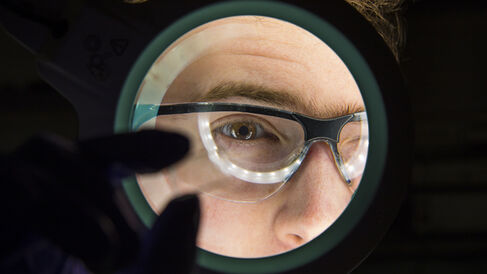 A scientist viewing a microfluidic chip.
