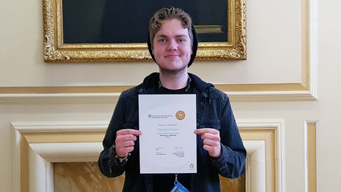 Riley Brown receives his National Vocational Qualification certificate.