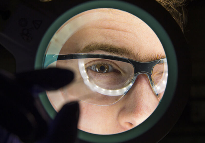 A scientist viewing a microfluidic chip.