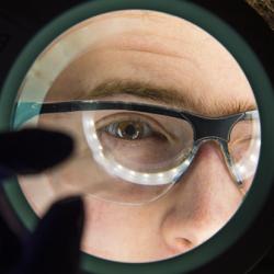 A scientist viewing a microfluidic chip.