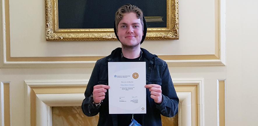 Riley Brown receives his National Vocational Qualification certificate.